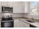 Close-up of a well-equipped kitchen with granite countertops and stainless steel appliances at 910 Rhino Bnd, Oxford, NC 27565