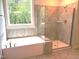 Bathroom showcasing a bathtub and glass-enclosed shower with tiled walls at 9164 Dupree Meadow Dr # 14, Angier, NC 27501