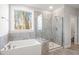 Bathroom showcasing a garden tub, glass-enclosed shower, and tiled walls at 9164 Dupree Meadow Dr # 14, Angier, NC 27501