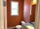 Powder room features orange accent wall, modern fixtures, a stylish mirror and a window at 9164 Dupree Meadow Dr # 14, Angier, NC 27501