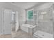 Bright bathroom featuring a large soaking tub, tiled walk-in shower, and natural lighting at 9164 Dupree Meadow Dr # 14, Angier, NC 27501
