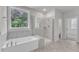 Bright bathroom featuring a large soaking tub, tiled walk-in shower, and picture window overlooking greenery at 9164 Dupree Meadow Dr # 14, Angier, NC 27501