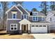 Charming two-story home with a blend of gray siding, stone accents, and a white garage door at 9164 Dupree Meadow Dr # 14, Angier, NC 27501