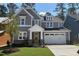 Charming two-story home with gray siding, stone accents, a yellow front door and an attached two-car garage at 9164 Dupree Meadow Dr # 14, Angier, NC 27501