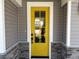 Close-up of a bright yellow front door with glass panels, framed by stone accents and gray siding at 9164 Dupree Meadow Dr # 14, Angier, NC 27501