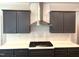 Updated kitchen featuring gray cabinets, a stainless steel range hood, and white countertops at 9164 Dupree Meadow Dr # 14, Angier, NC 27501