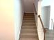 Carpeted staircase with wooden handrail at 9164 Dupree Meadow Dr # 14, Angier, NC 27501