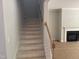 View of a staircase leading upstairs, near an electric fireplace and light-filled living area at 9164 Dupree Meadow Dr # 14, Angier, NC 27501