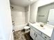 Bathroom with shower-tub combo, gray tile floor, white vanity and large mirror at 111 Southern Estates Dr, Sanford, NC 27330