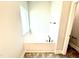 Relaxing soaking tub with a window for natural light in a neutral bathroom at 111 Southern Estates Dr, Sanford, NC 27330