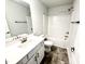 Well-lit bathroom with shower-tub, gray tile floor, white vanity and large mirror at 111 Southern Estates Dr, Sanford, NC 27330