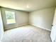 Bright bedroom featuring neutral walls and plush carpet, with a window providing natural light at 111 Southern Estates Dr, Sanford, NC 27330