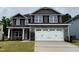 Charming two-story home with a gray stone base, two-car garage, and a well-manicured front lawn at 111 Southern Estates Dr, Sanford, NC 27330