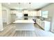 Bright kitchen with a large island, white cabinets and stainless steel appliances at 111 Southern Estates Dr, Sanford, NC 27330