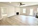 Bright living room with a cozy fireplace, ceiling fan, wood flooring, and access to the backyard at 111 Southern Estates Dr, Sanford, NC 27330