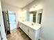 Elegant bathroom featuring a double vanity with white cabinets and a large mirror at 111 Southern Estates Dr, Sanford, NC 27330