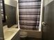 Bathroom showcasing a sink and toilet next to a bathtub and shower with a striped shower curtain at 165 Wakeline Dr, Wendell, NC 27591