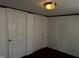 A bedroom features two white doors, neutral walls, and ample lighting from the ceiling light at 165 Wakeline Dr, Wendell, NC 27591