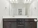 Double vanity bathroom with dark brown cabinets and large mirror at 1819 Capstone Dr, Durham, NC 27713