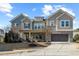 Two-story home with gray siding, stone accents, and a three-car garage at 1819 Capstone Dr, Durham, NC 27713