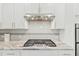 Gas cooktop with granite countertops and white cabinets at 1819 Capstone Dr, Durham, NC 27713
