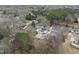 An aerial view of a charming home nestled among trees with a white picket fence and several outbuildings at 210 W Oak Ave, Wake Forest, NC 27587