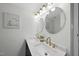 Bright bathroom featuring a double vanity with gold hardware and two round mirrors at 210 W Oak Ave, Wake Forest, NC 27587
