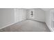 Bedroom featuring plush carpet, paneled closet doors, and natural light from two windows at 210 W Oak Ave, Wake Forest, NC 27587