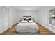 This bedroom is bright and inviting with white walls, hardwood floors, and a cozy rug at 210 W Oak Ave, Wake Forest, NC 27587