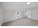 Empty bedroom with neutral carpet and paint, featuring a view of the neighborhood at 210 W Oak Ave, Wake Forest, NC 27587
