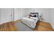 Bedroom includes wood flooring, crisp white walls, and a contemporary rug at 210 W Oak Ave, Wake Forest, NC 27587