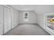 Cozy bedroom with neutral carpet, two windows, and a closet with paneled doors at 210 W Oak Ave, Wake Forest, NC 27587
