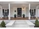 Inviting front porch with rocking chairs, planters, and a welcome mat at the front door at 210 W Oak Ave, Wake Forest, NC 27587