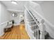Bright hallway with hardwood floors, a staircase, and a bench with accent pillows at 210 W Oak Ave, Wake Forest, NC 27587