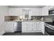 Bright kitchen features white cabinets, granite countertops, stainless steel appliances and a window at 210 W Oak Ave, Wake Forest, NC 27587