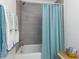 Updated bathroom showcasing gray tiled walls and a blue textured shower curtain at 211 Long Ave, Graham, NC 27253