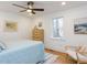 Bedroom showcasing a ceiling fan, wood floors, and ample natural light at 211 Long Ave, Graham, NC 27253