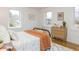 Bright bedroom with wood floors, two windows, and stylish furnishings at 211 Long Ave, Graham, NC 27253