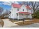 Charming two-story home with red roof, covered porch, and paved driveway at 211 Long Ave, Graham, NC 27253
