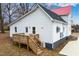 Exterior showcasing a white house with a red roof and wooden deck with stairs at 211 Long Ave, Graham, NC 27253
