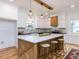 Modern kitchen featuring white cabinetry, a large island with seating, and stylish pendant lighting at 211 Long Ave, Graham, NC 27253