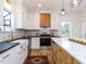 Well-lit kitchen with white cabinets, modern appliances, farmhouse sink, and spacious island for cooking at 211 Long Ave, Graham, NC 27253