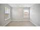 Neutral-colored room with two windows for ample natural light, and neutral carpeted flooring at 212 War Admiral Dr, Clayton, NC 27520
