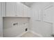 Bright laundry room with white cabinets and tile flooring at 212 War Admiral Dr, Clayton, NC 27520