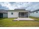 Backyard view of the screened porch and its concrete patio surrounded by a well maintained lawn at 212 War Admiral Dr, Clayton, NC 27520