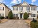 Two-story townhome with light beige siding, gray shutters, and a shared driveway at 2321 Turtle Point Dr, Raleigh, NC 27604