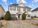 Two-story townhome with light beige siding, gray shutters, and a shared driveway at 2321 Turtle Point Dr, Raleigh, NC 27604