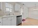 Well-lit kitchen featuring white cabinets, stainless steel dishwasher, and a sink beneath a window at 2321 Turtle Point Dr, Raleigh, NC 27604