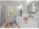 Bright bathroom with double vanities, round mirrors, modern fixtures, and a glass-enclosed shower at 260 Ellington Rd, Graham, NC 27253
