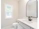 Modern bathroom with white cabinets, quartz countertop, black arched mirror and faucets, and a toilet at 260 Ellington Rd, Graham, NC 27253